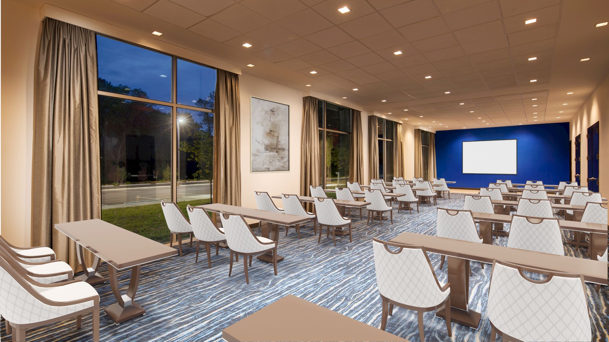 A modern conference room with neatly arranged tables and white chairs, large windows with curtains, and a projector screen at the front of the room.